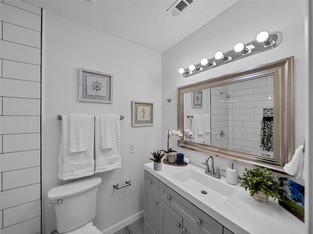 bathroom featuring vanity, toilet, and walk in shower