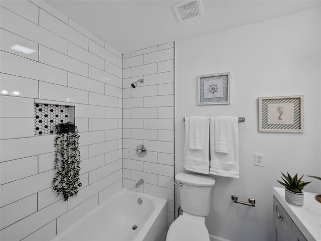 full bathroom with tiled shower / bath, vanity, and toilet