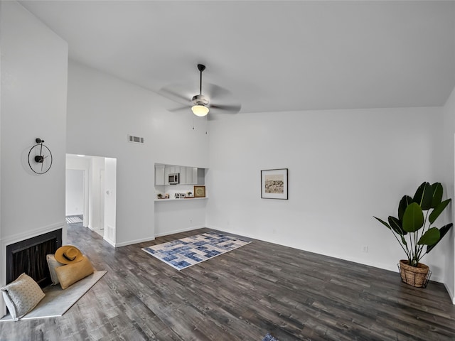 living room featuring high vaulted ceiling, dark hardwood / wood-style floors, and ceiling fan