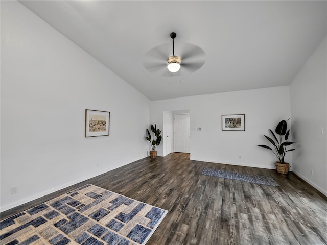 empty room with dark hardwood / wood-style flooring, lofted ceiling, and ceiling fan