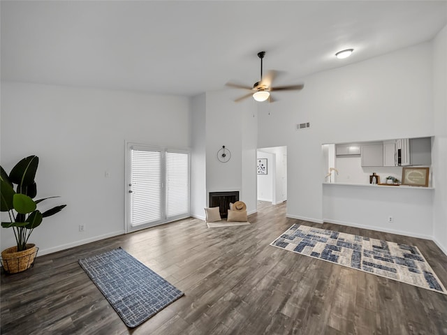 living room with dark hardwood / wood-style flooring, high vaulted ceiling, and ceiling fan