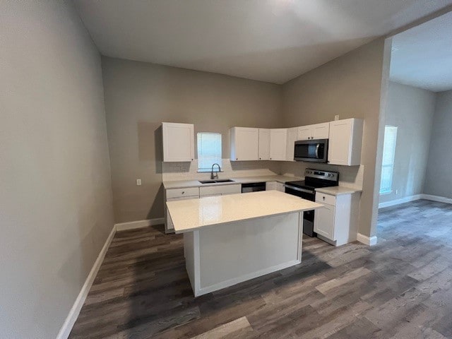 kitchen featuring stainless steel appliances, sink, a kitchen island, and white cabinets