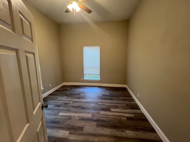 empty room with dark hardwood / wood-style floors and ceiling fan