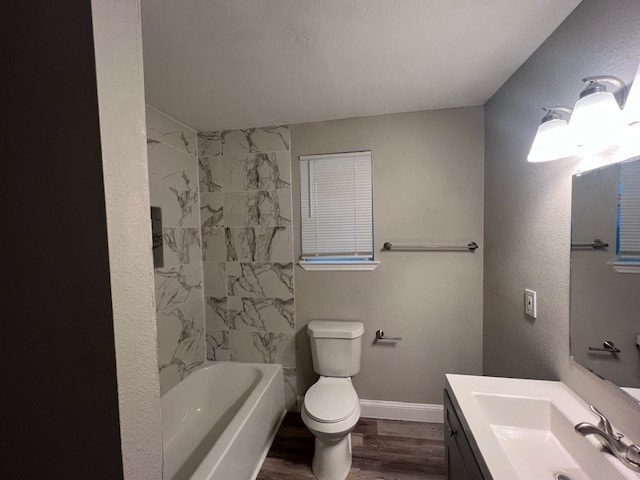 full bathroom with vanity, tiled shower / bath, wood-type flooring, and toilet