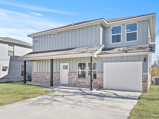 view of front facade with a garage, a front yard, and central AC unit