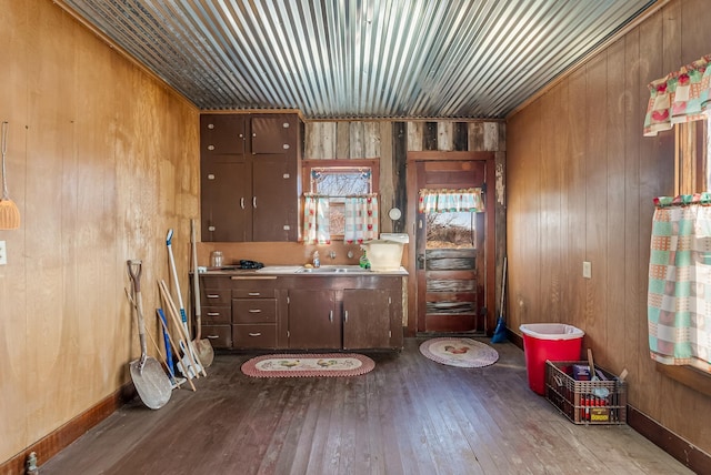 misc room featuring sink, wooden walls, and light hardwood / wood-style floors