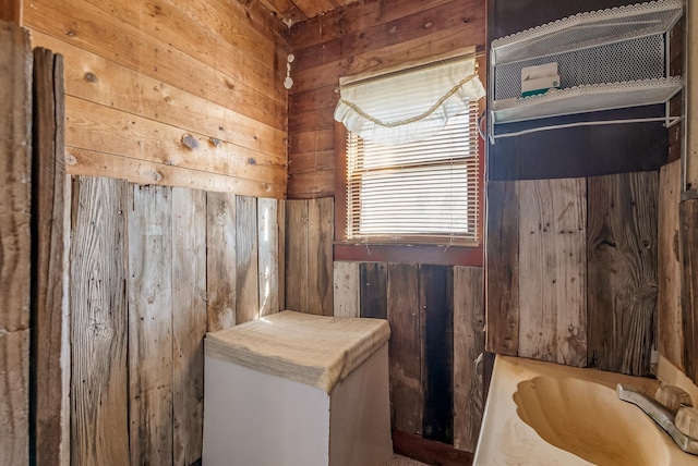 bathroom with sink and wooden walls