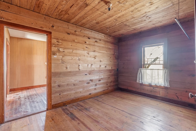 empty room with wooden walls, hardwood / wood-style floors, and wooden ceiling