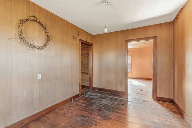 empty room featuring wood-type flooring and wood walls