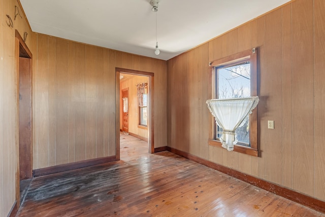 spare room featuring dark hardwood / wood-style flooring and wood walls