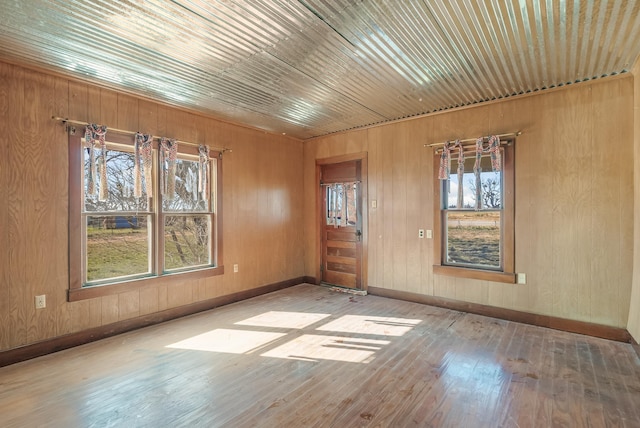 unfurnished room featuring wood ceiling, hardwood / wood-style flooring, and wooden walls