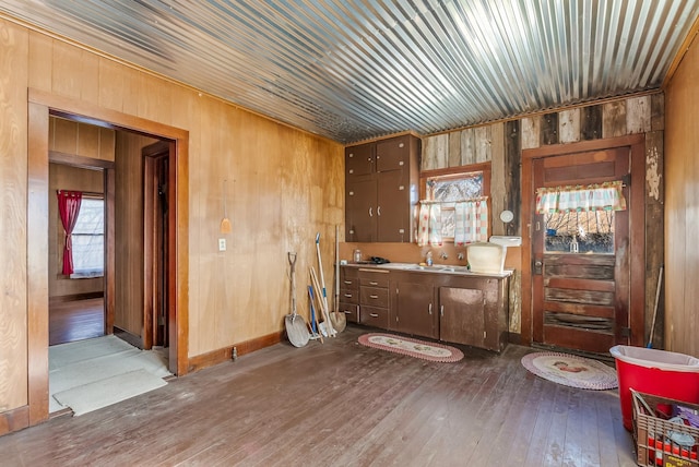 miscellaneous room featuring dark wood-type flooring, wooden walls, and sink