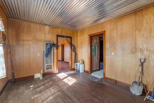 empty room with dark hardwood / wood-style flooring and wood walls