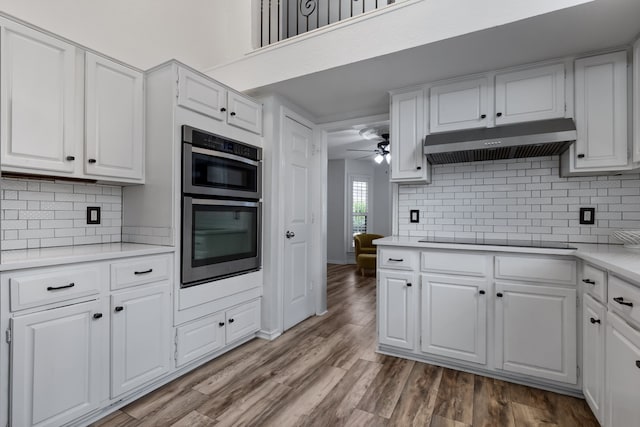 kitchen with black electric cooktop, stainless steel double oven, and white cabinets