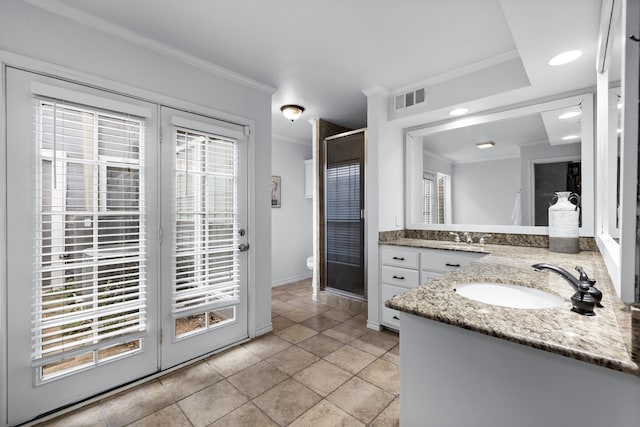 bathroom with vanity, toilet, a shower with door, crown molding, and tile patterned floors