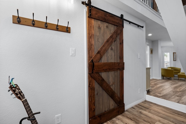 corridor featuring a barn door and light wood-type flooring