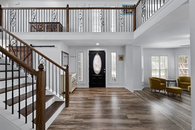 entrance foyer with a towering ceiling and wood-type flooring