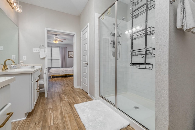 bathroom featuring ceiling fan, vanity, a shower with shower door, and hardwood / wood-style floors