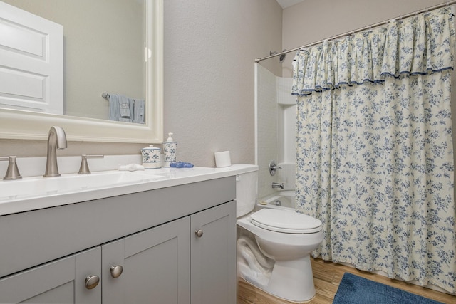 full bathroom with vanity, hardwood / wood-style flooring, shower / bath combo, and toilet