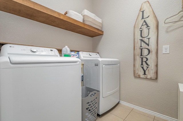 laundry room featuring separate washer and dryer and light tile patterned floors