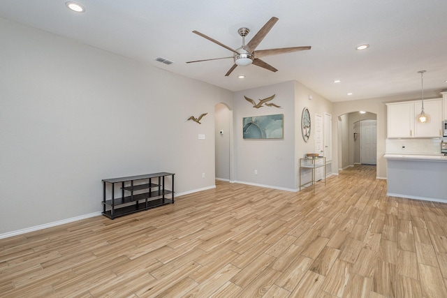 unfurnished living room featuring ceiling fan and light wood-type flooring