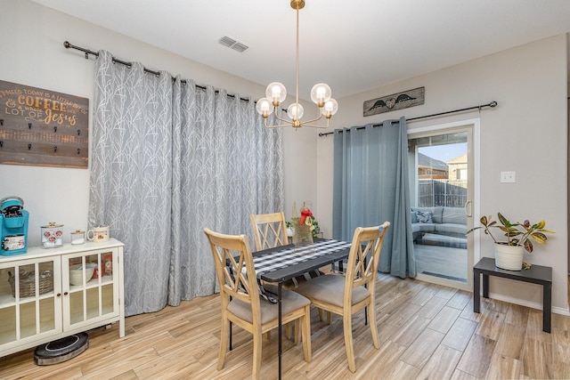 dining area with wood-type flooring and a chandelier