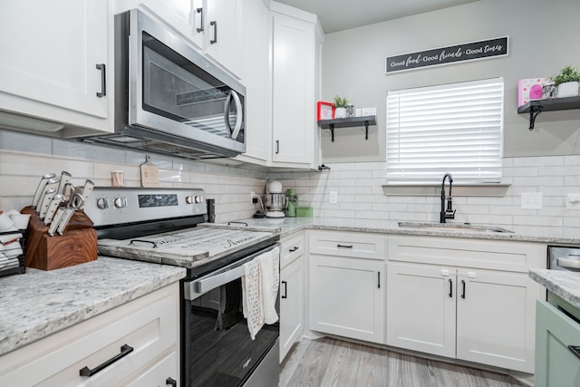 3010 Morris Rd, Mabank, TX 75147 - kitchen featuring stainless steel appliances, open shelves, a sink, and white cabinetry
