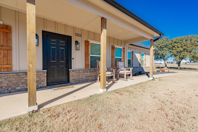 3010 Morris Rd, Mabank, TX 75147 - view of exterior entry featuring board and batten siding, a porch, and brick siding