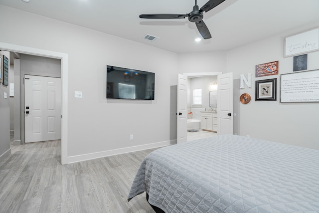 bedroom with ceiling fan, ensuite bath, and light wood-type flooring