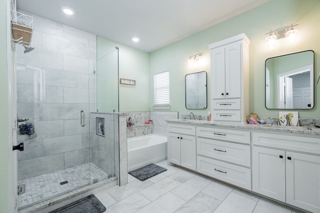 bathroom with tile patterned floors, independent shower and bath, and vanity