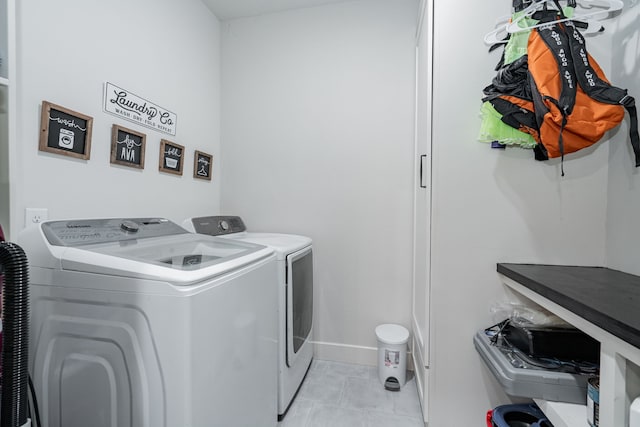 laundry room featuring washer and clothes dryer and light tile patterned floors