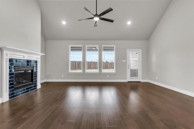 unfurnished living room featuring high vaulted ceiling, wood finished floors, and a tile fireplace