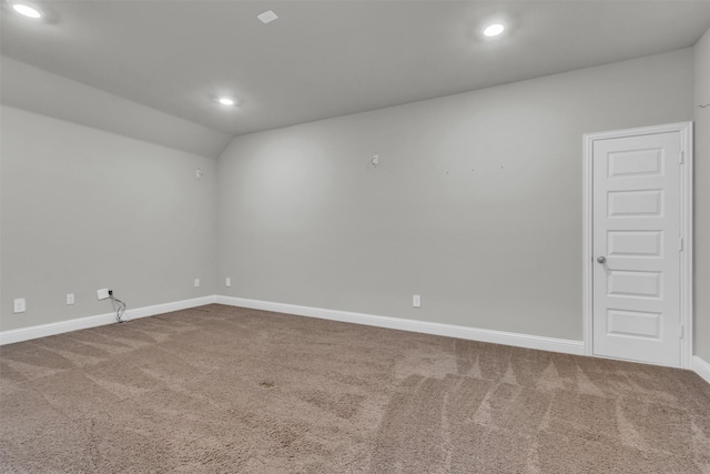 carpeted spare room featuring recessed lighting, baseboards, and lofted ceiling