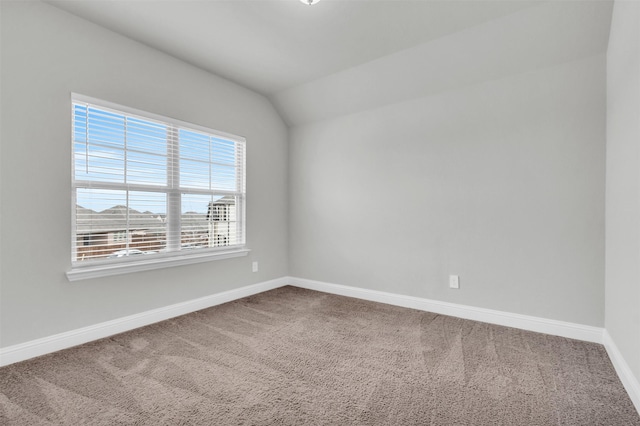 unfurnished room with vaulted ceiling, baseboards, and carpet floors