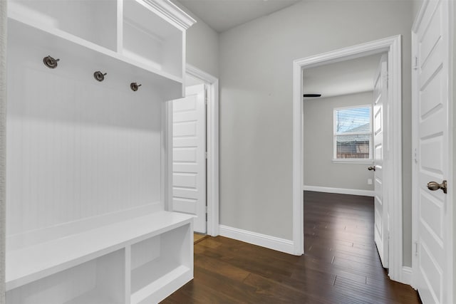 mudroom with dark wood-type flooring and baseboards