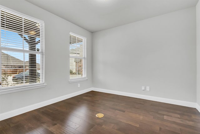 empty room with baseboards and dark wood-style flooring