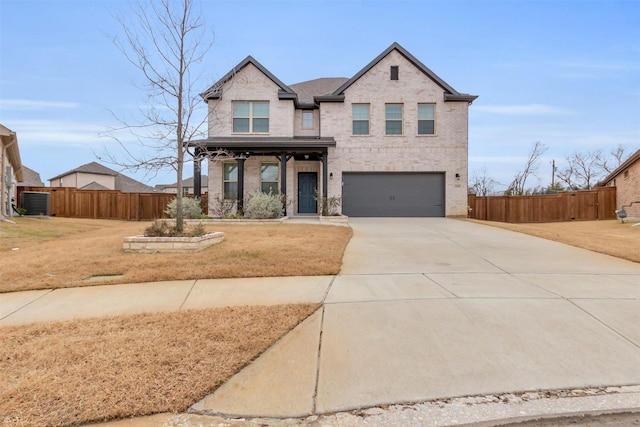 traditional home featuring brick siding, an attached garage, driveway, and fence