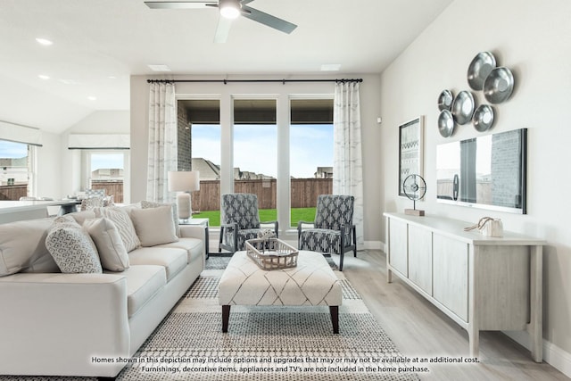 living room with lofted ceiling, light hardwood / wood-style floors, and ceiling fan