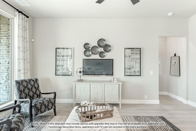 living area featuring ceiling fan and light hardwood / wood-style flooring