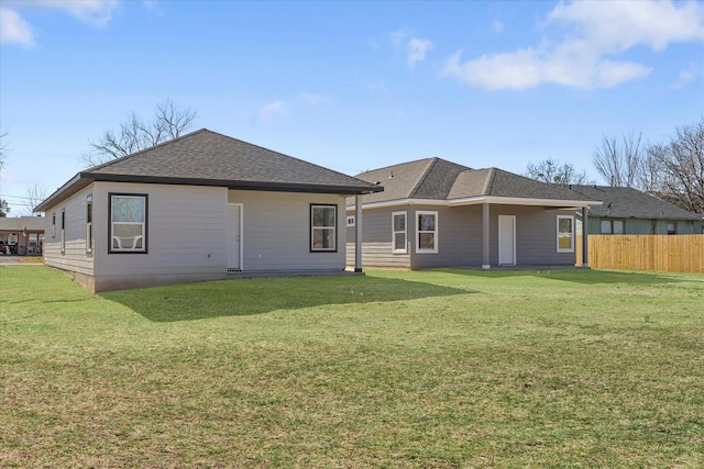 rear view of property featuring a lawn