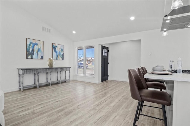 interior space with lofted ceiling and light hardwood / wood-style flooring