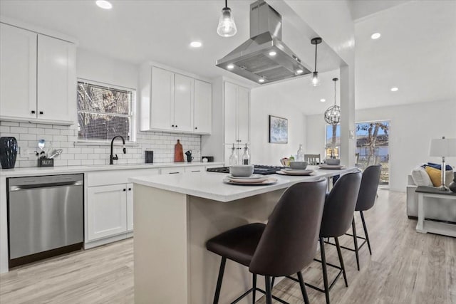 kitchen featuring pendant lighting, white cabinetry, a center island, island range hood, and stainless steel dishwasher