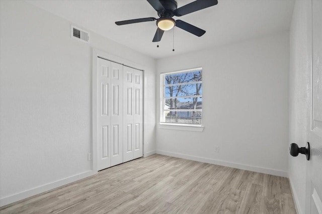 unfurnished bedroom featuring light hardwood / wood-style flooring, a closet, and ceiling fan