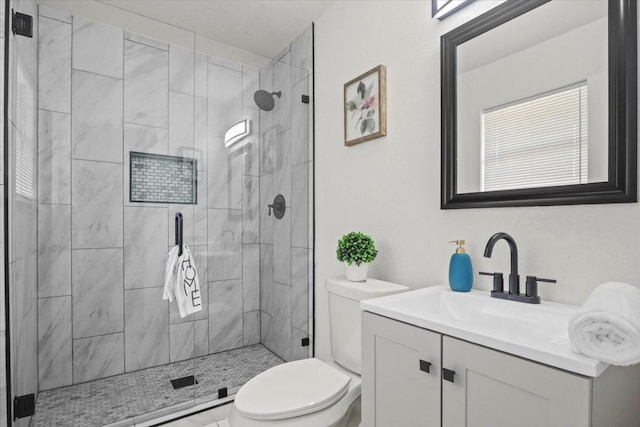 bathroom featuring vanity, an enclosed shower, and toilet