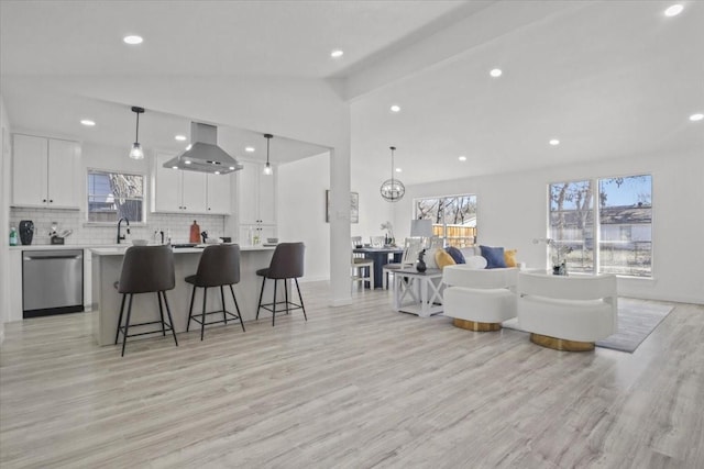 living room with sink, light hardwood / wood-style floors, and lofted ceiling with beams