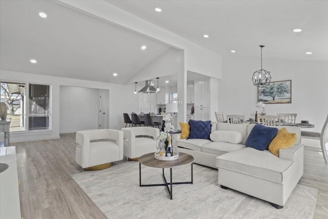 living room with an inviting chandelier, light hardwood / wood-style flooring, high vaulted ceiling, and beamed ceiling