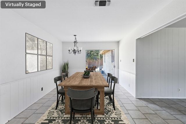 dining space featuring an inviting chandelier, light tile patterned floors, visible vents, and wainscoting