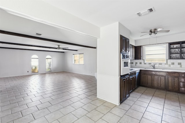 kitchen featuring light tile patterned floors, visible vents, open floor plan, white oven, and light countertops