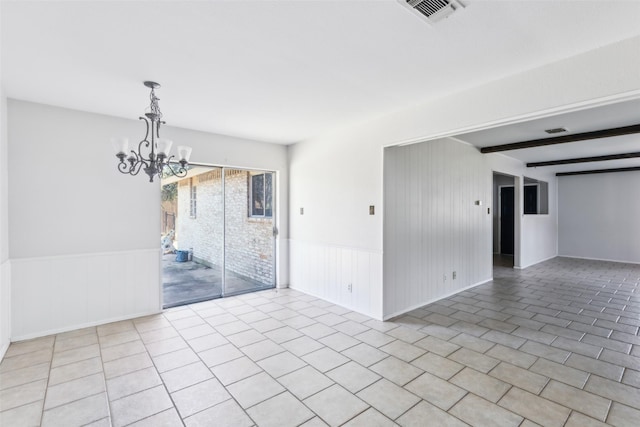 spare room with a wainscoted wall, visible vents, a notable chandelier, and beamed ceiling