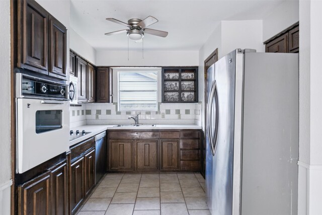 kitchen with light tile patterned floors, a sink, light countertops, appliances with stainless steel finishes, and decorative backsplash